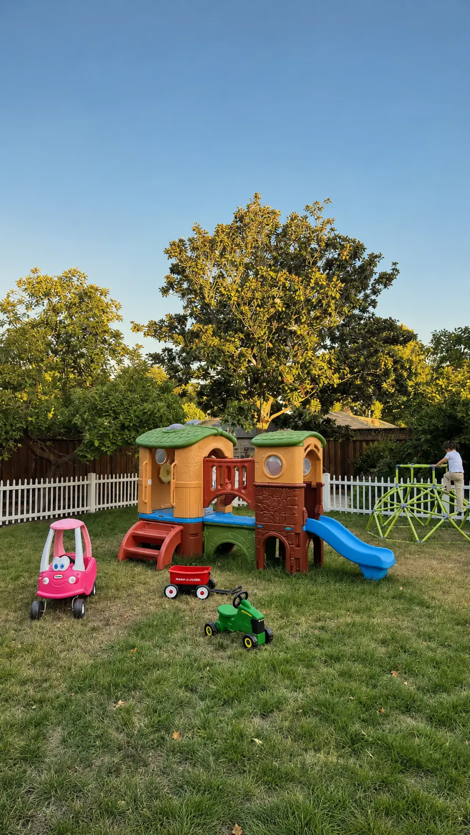 Another view of the fenced outdoor playground and play equipment